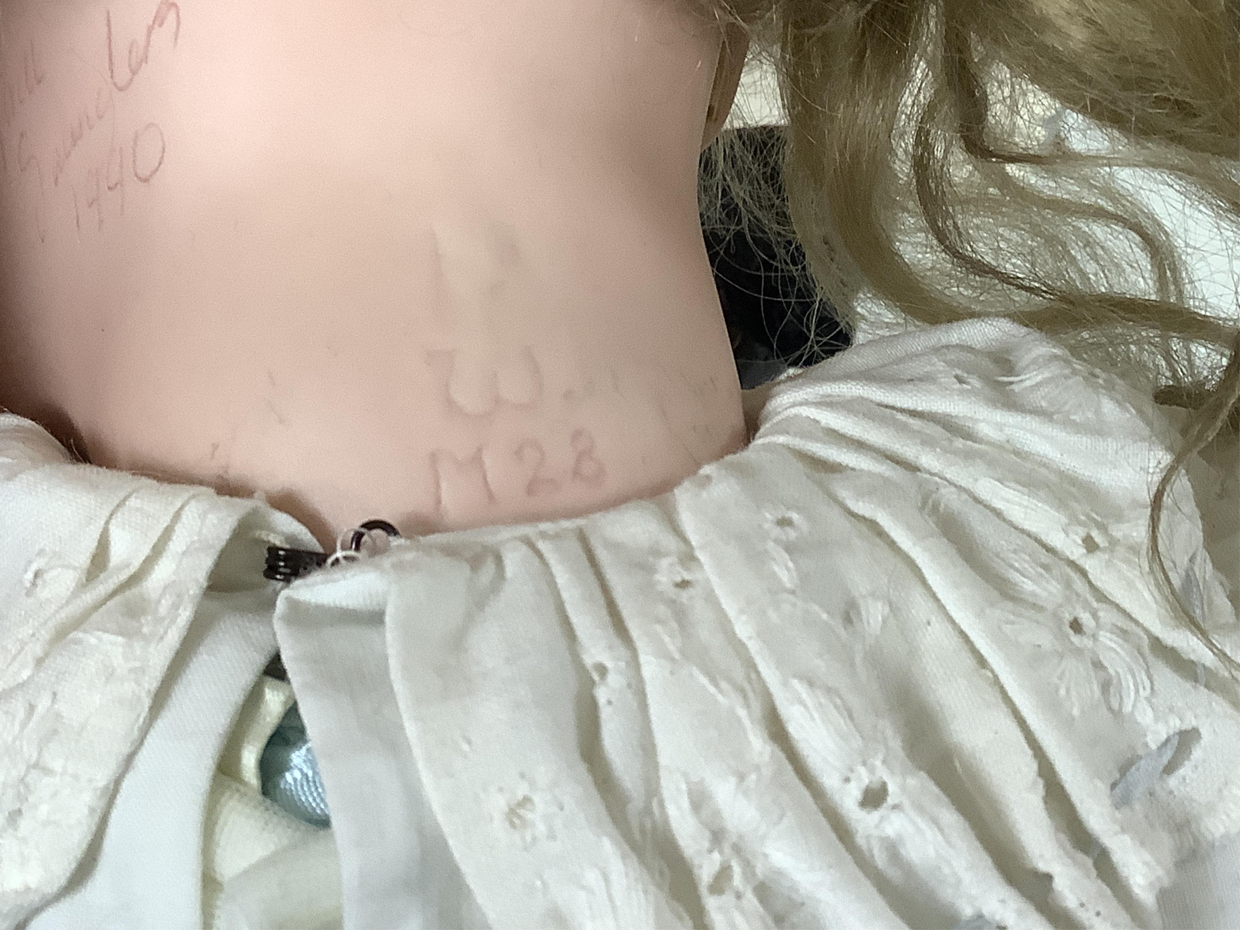 A large jointed bisque head doll and two miniature bisque dolls